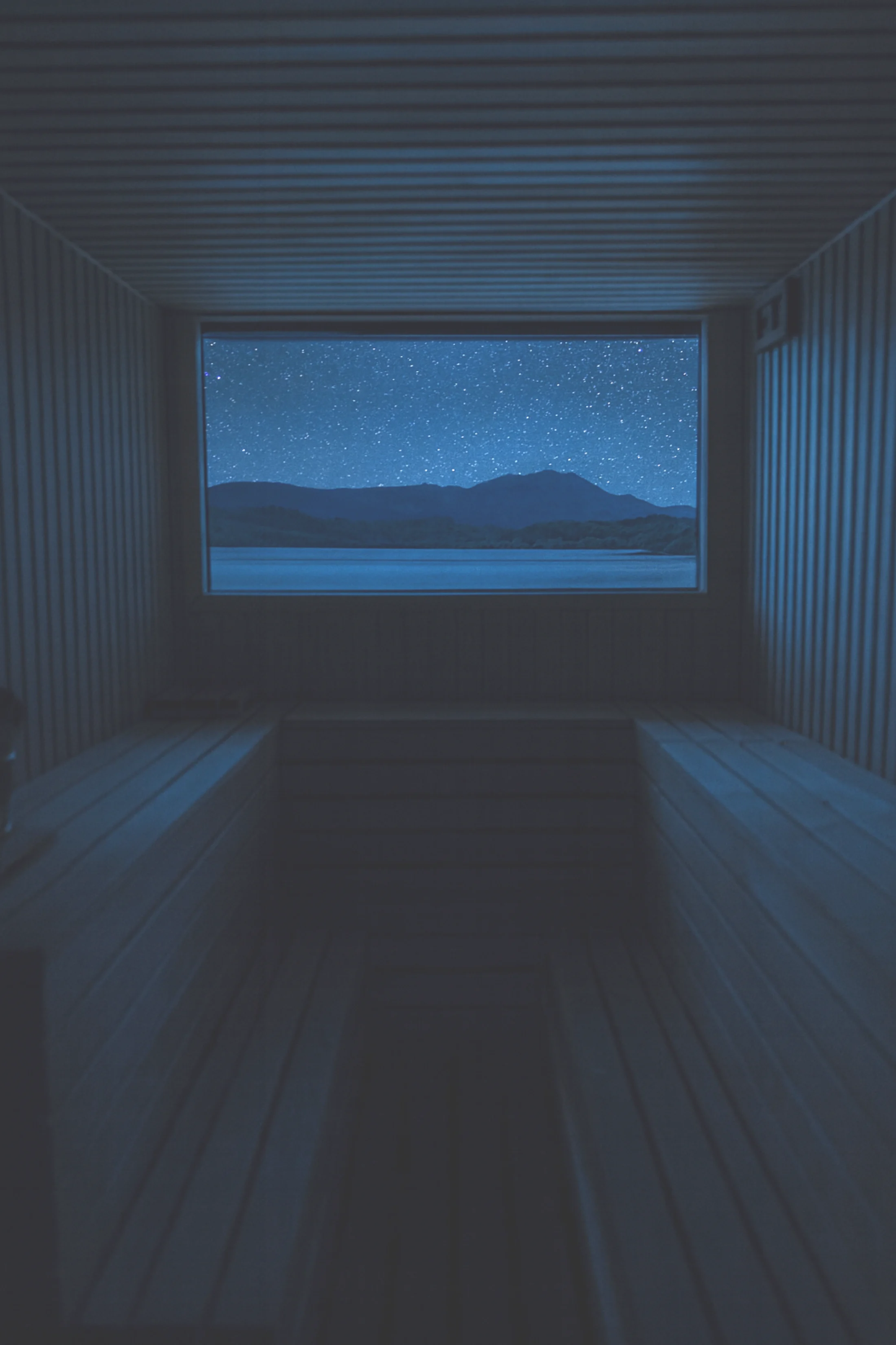 Starry night sky over the loch from inside the sauna