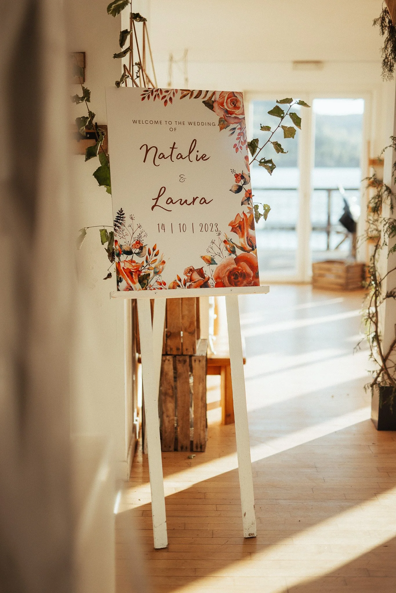Wedding welcome sign on an easel in the sunlit entrance